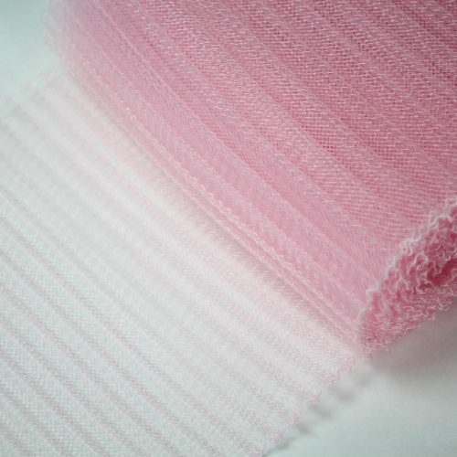 Pink polyester, very flexible, 1/4 inch pleats.
